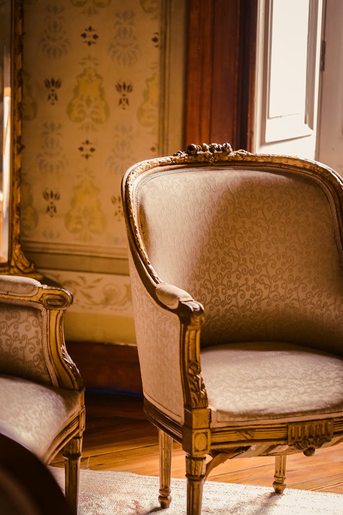 Vintage armchairs in a sunlit classic room, showcasing elegant upholstery and wooden craftsmanship.