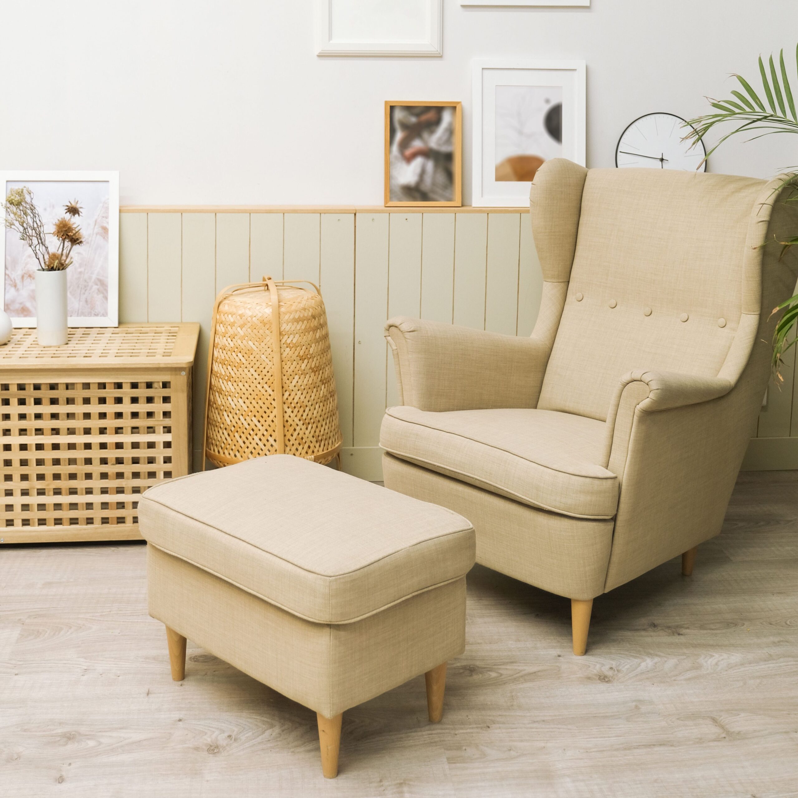 Cozy living room with beige armchair, pouf, and minimalist decor.